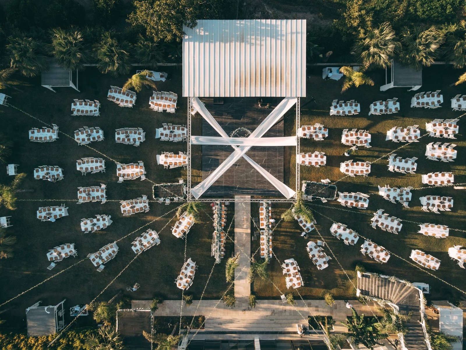 An overhead view of tables and chairs laid out in rows on a lawn for an event.